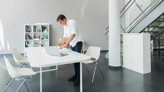 Man working on a table standing up